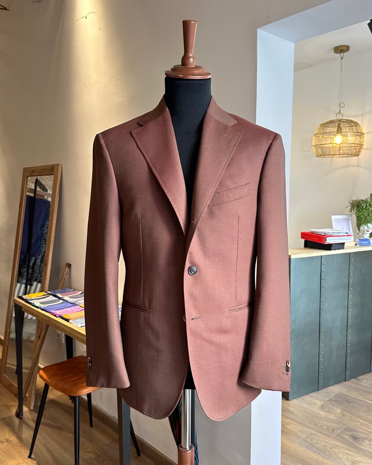 A tailored jacket on a stand in a partner brand showroom.