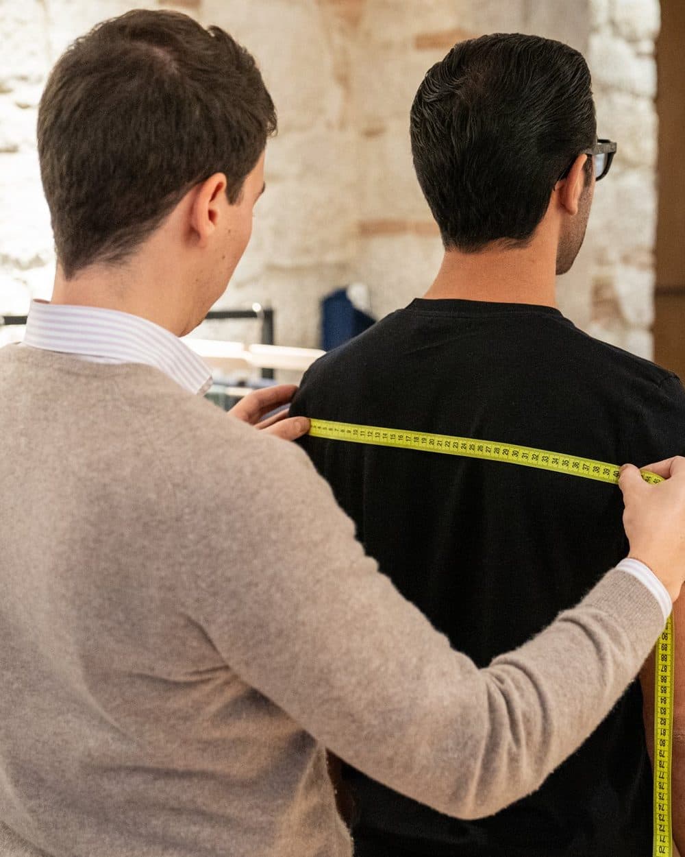 A tape measure across a client's shoulders: the measurements that become your Size Passport.