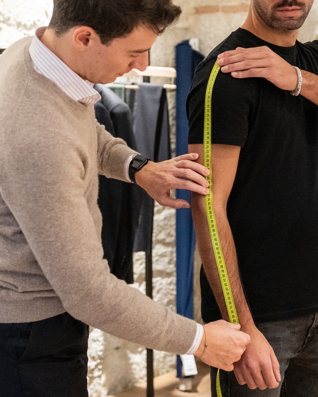 A tape measure along a client's arm: one of the measurements your Size Passport keeps for you.